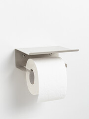 Beige steel toilet paper holder on white background. Storage in the toilet room