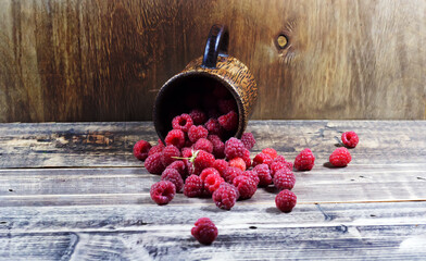 Raspberries in a wooden glass on a wooden background