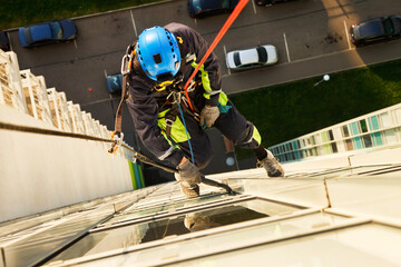 Concept of industry urban works. Top view Industrial mountaineering worker hangs over residential...