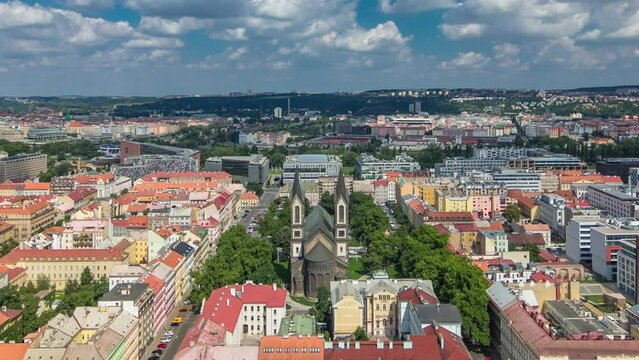Panoramic view of Prague and church of Saints Cyril and Methodius timelapse from the top of the Vitkov Memorial, Czech Republic. Old Town with red roofs. Cloudy sky at summer day