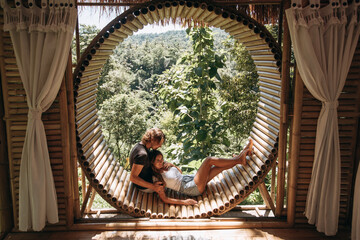 Happy couple in love in bamboo house with jungle view. Eco housing. Healthy lifestyle, outdoor recreation