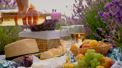 A woman drinks wine in a lavender field. Selective focus.