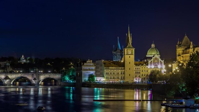 View of the city Prague in Czech Republic with colorful boats day to night transition timelapse on the Vltava river with beautiful sky. Charles bridge on background and Staromestsky water tower