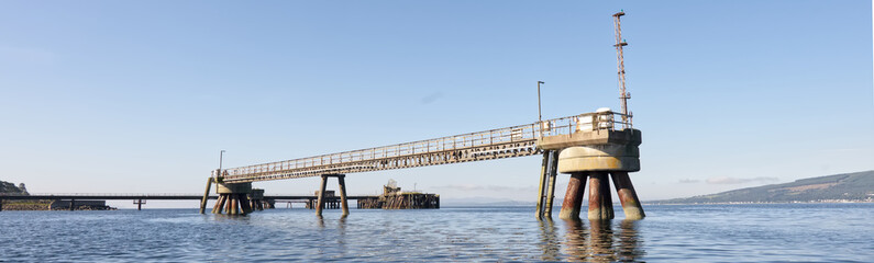 Old derelict wooden jetty pier in sea at Inverkip power station