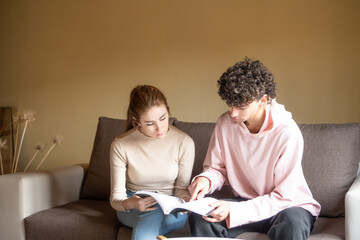young people reading a book at home.