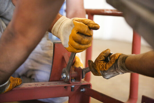 worker hand tightening industrial screw