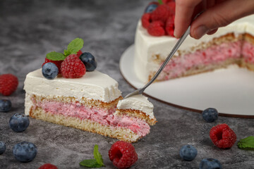 A piece of raspberry mint cake decorated with fresh raspberry and mint leaves