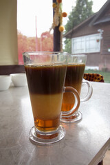 Coffee with syrup and cream. In glass mugs. The layers of the drink are visible.