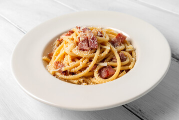 Piatto di deliziosi bucatini alla gricia, ricetta tipica romana di pasta condita con pecorino e...