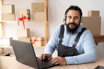 Starting small business entrepreneur taking online order using laptop and headphones while sitting at home office, dropshipping and goods delivery, SME e-commerce, telemarketing
