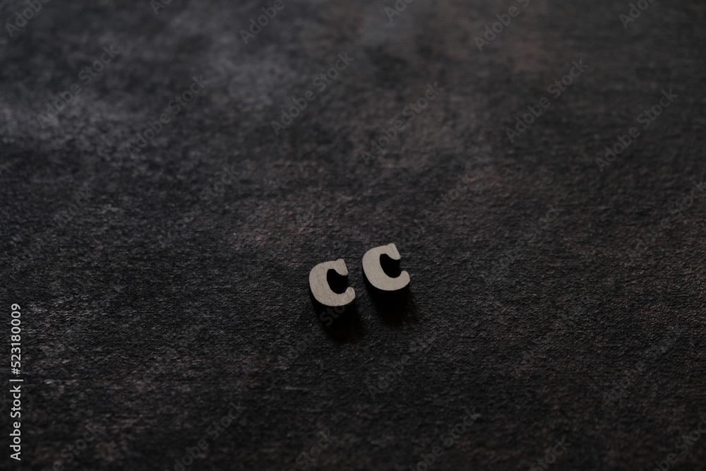 Fototapete the letters c and c above the dark field. initials cc
