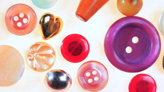 Different types of decorative buttons for use on bags, clothes and wallets. Functional buttons in pearl and gold colors on wooden table background. Sewing accessories of high quality
