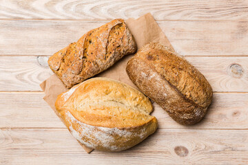 Assortment of freshly baked bread with napkin on rustic table top view. Healthy unleavened bread. French bread