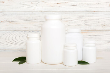 supplement pills with medicine bottle health care and medical top view. Vitamin tablets. Top view mockup bottle for pills and vitamins with green leaves, natural organic bio supplement, copy space