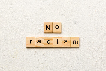 No racism word written on wood block. No racism text on table, concept