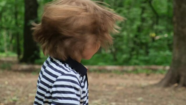 Little boy shakes his head in different directions and rubs his hair Slow motion