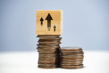 Capital growth concept. Increasing savings and capitalization. Stack of coins with up arrows.
