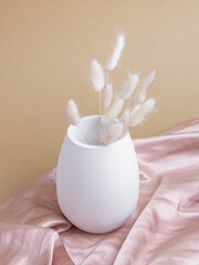 Fototapeta na wymiar Plaster white vase and dried flowers on beige background. Vase for dried flowers