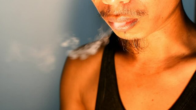 Close up of man smoking vapor from electronic cigarette device
