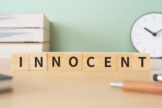 無実・潔白のイメージ｜「INNOCENT」と書かれたブロックが置かれたデスク
