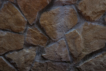 Imitation of a brown stone wall in close-up.
