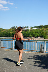 A vertical shot of young female wearing sporty cloth and jumping rope