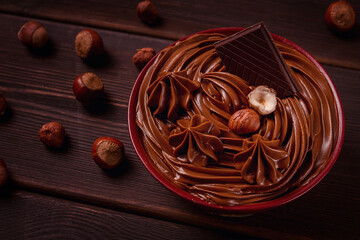 Chocolate nut paste, mousse, pasta, in a cup, on a wooden table, top view, selective focus, no people,