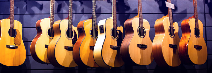 Selective focus to guitar in music shop, many guitars, pop rock artist song music and entertainment instrument.