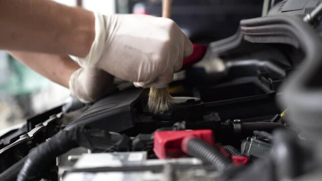 An auto mechanic is cleaning the engine compartment. car service. close-up.