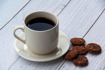 Coffee cup and cookies on wooden floor. Copy space