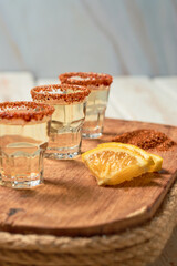 Mexican mezcal shots with slice of orange fruit adn chili