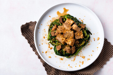 Adobong Kangkong (Water spinach) topped with fried tofu and pork sprinkled with toasted garlic bits