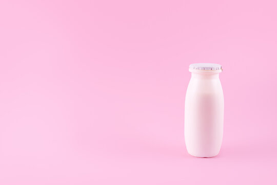 Natural liquid yogurt with probiotics in small plastic bottles on pink background. Healthy, balanced diet food, healthy breakfast, dairy products. Selective soft focus, blurred background.