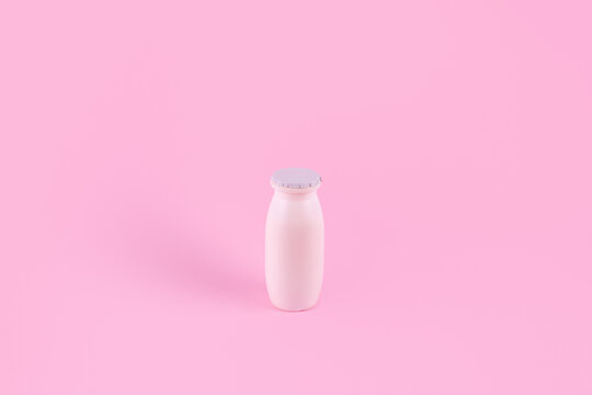 Natural liquid yogurt with probiotics in small plastic bottles on pink background. Healthy, balanced diet food, healthy breakfast, dairy products. Selective soft focus, blurred background.