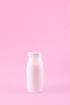 Natural liquid yogurt with probiotics in small plastic bottles on pink background. Healthy, balanced diet food, healthy breakfast, dairy products. Selective soft focus, blurred background.