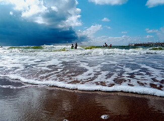 Baltic sea in summer time. Children swimming in the waves.