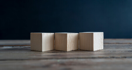 Blank wooden cube blocks on the table. Three pieces are placed side by side, six sides