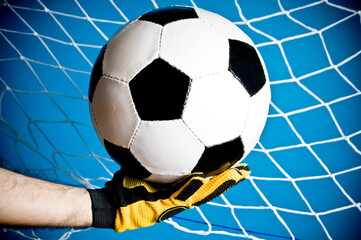 goalkeeper hands grabbing a ball preventing a goal
