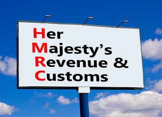 HMRC her majestys revenue and customs symbol. Concept words HMRC her majestys revenue and customs on billboard against blue sky and clouds. Business HMRC revenue and customs concept. Copy space.