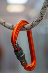 Bright orange aluminum climbing carabiner on a rope