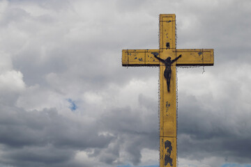 Golden cross on a background of clouds. Close-up of a large cross