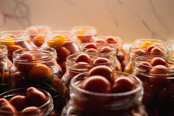 Homemade pickled tomatoes in glass jars on a wooden table. Homemade canned tomatoes. Village kitchen. Autumn canning. Conservation of farm harvest