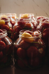 Homemade pickled tomatoes in glass jars on a wooden table. Homemade canned tomatoes. Village kitchen. Autumn canning. Conservation of farm harvest
