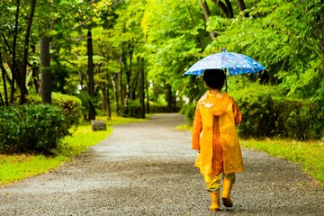 雨の中を歩く男の子