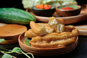 This is Cakwe or Fried Bread, Traditional Chinese Snacks with a long oval shape. With cucumber, chili sauce, white cabbage as a complement