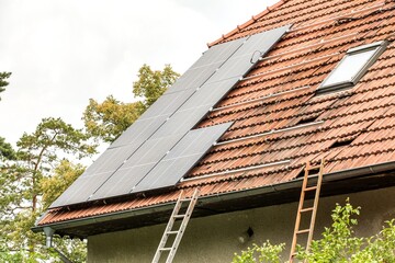 New solar panels on the roof of a private house. Renewable energy concept. Iinstallation of...