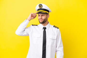 Airplane caucasian pilot isolated on yellow background having doubts and with confuse face expression