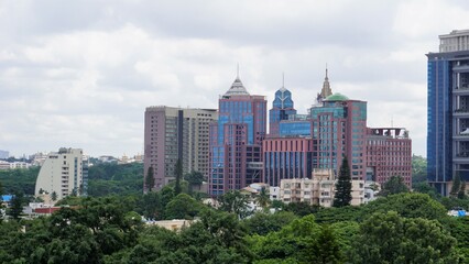 Bangalore,Karnataka,India-June 19 2022: View of Bangalore cityscape from terrace of Chancery Pavilion Hotel. Stadium and skyscrapers such as Prestige UB City Concorde Block visible through green cover