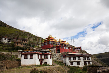 Fototapeta na wymiar Tibetan monastery on a hill with monk quarters and main hall in Sichuan province
