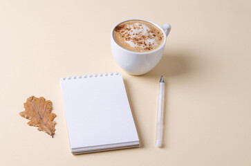Empty white notepad with a cup of coffee on a light background